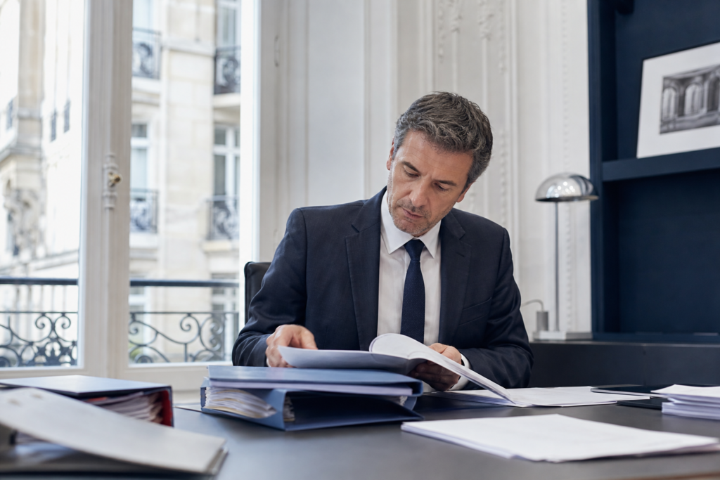 Conseiller préparant un dossier de due diligence cession PME sur un bureau professionnel