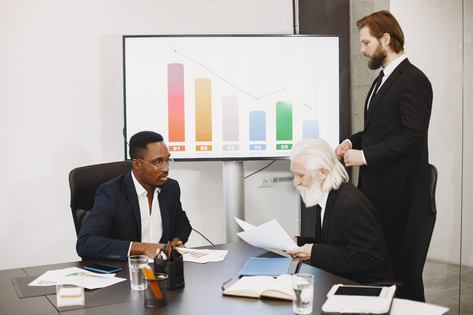 M&A documentation preparation for LBOs: Advisors reviewing financial and legal documents in a boardroom setting.